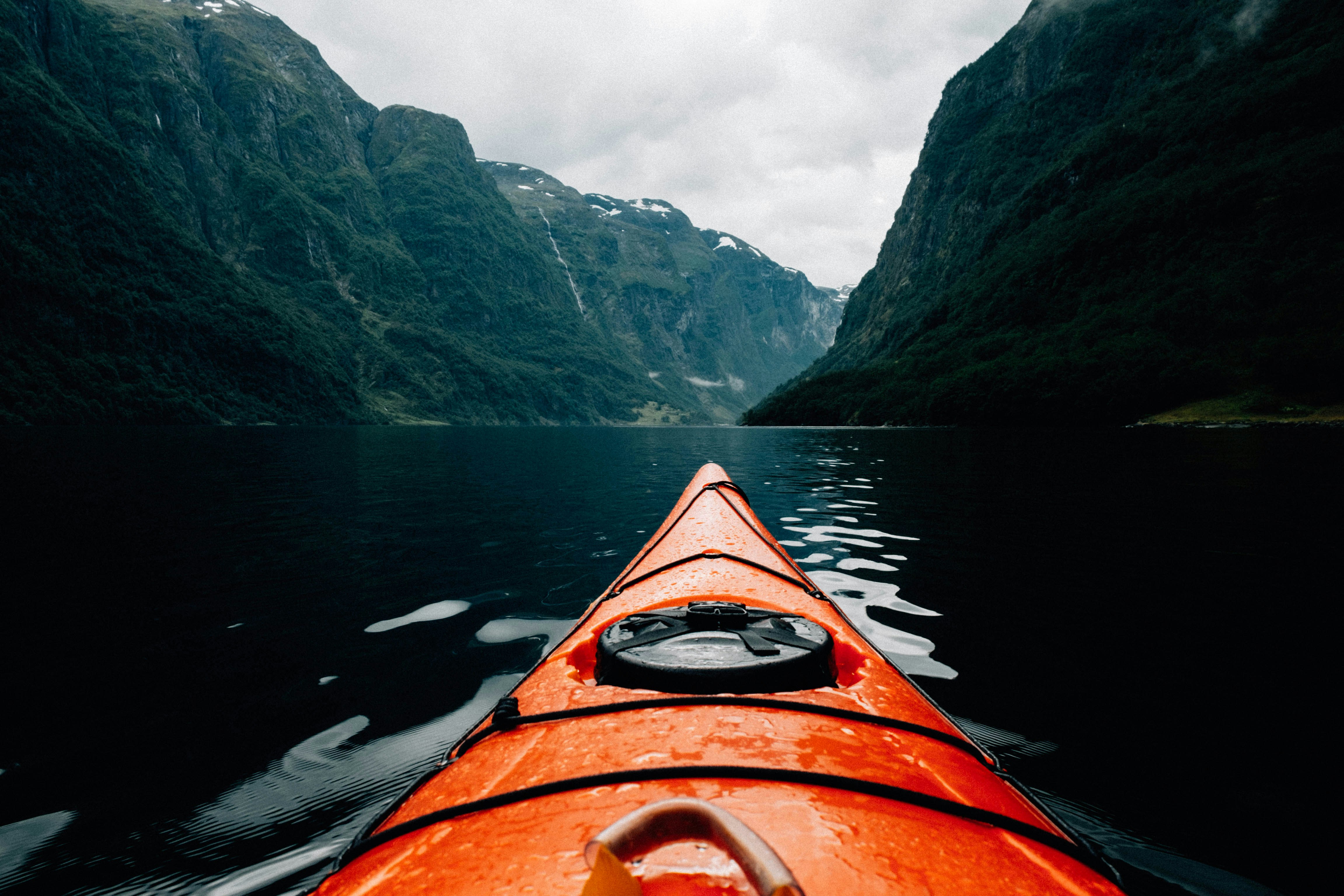 Kayaking between green fjord cliffs